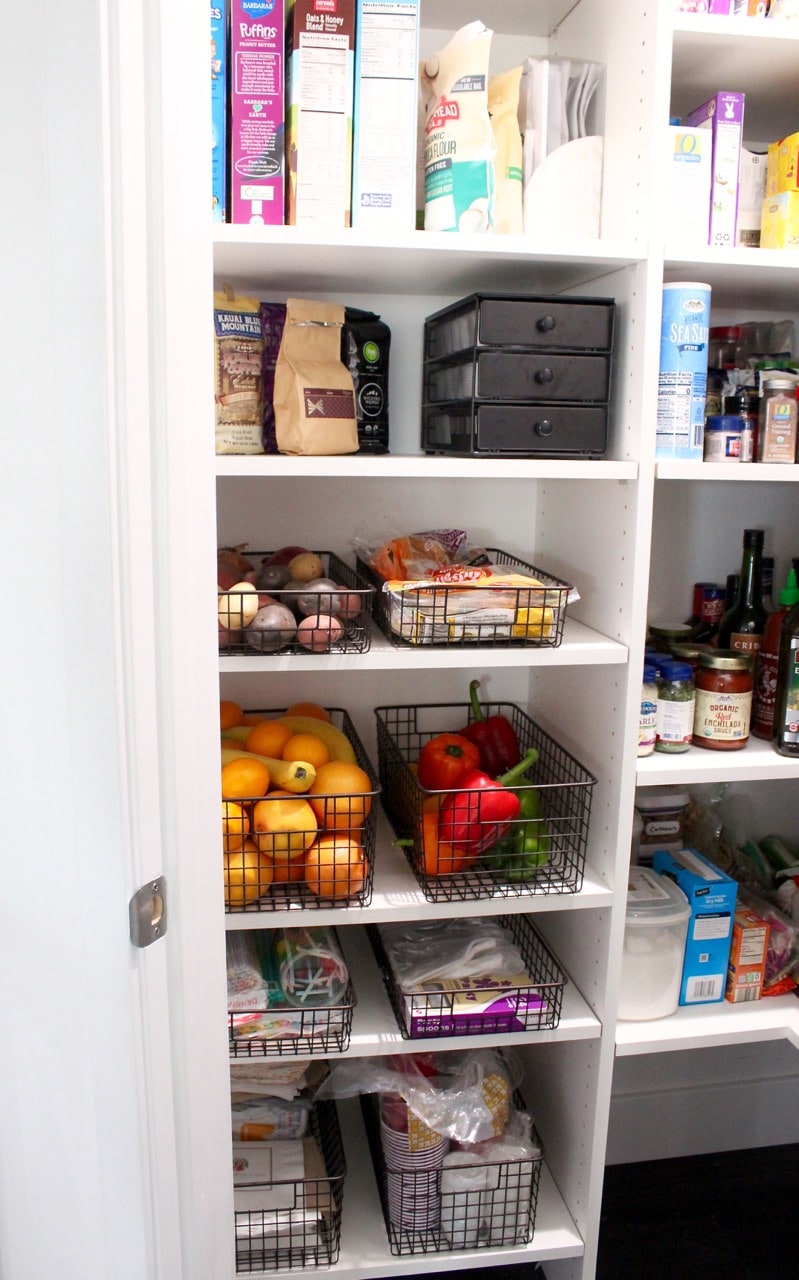 Kitchen pantry organization for fruit, veggies and plasticware.