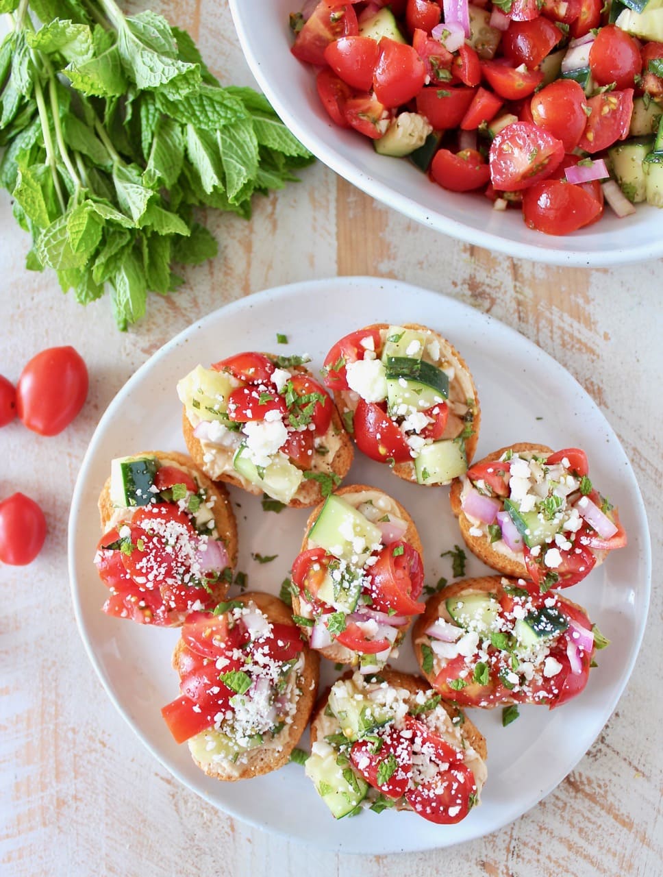 Tomato Cucumber Greek Bruschetta on Toasted Bread, topped with Garlic Hummus and Feta Cheese