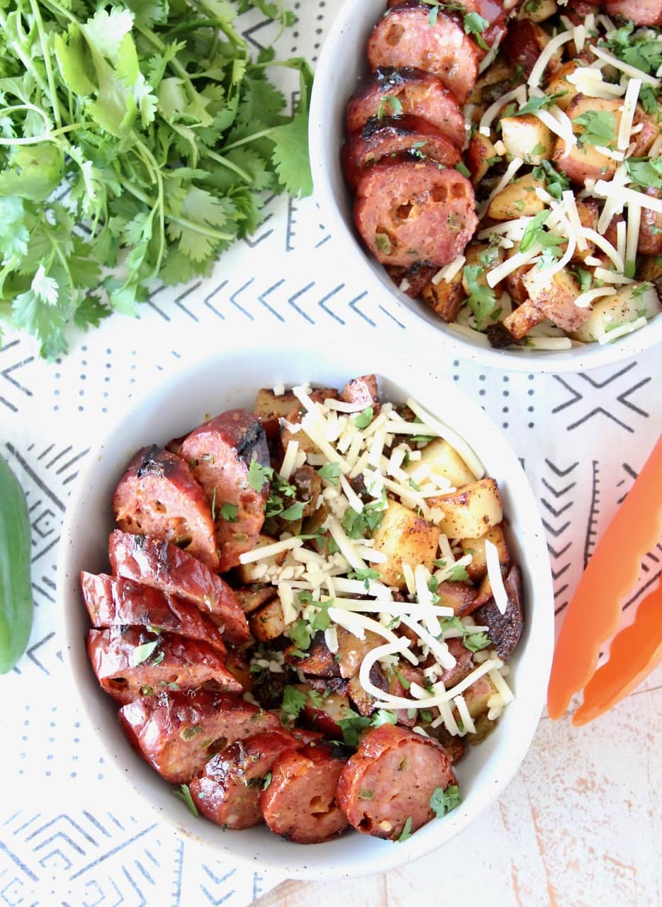 Grilled Jalapeno Cheddar Sausage in a bowl with Grilled Potatoes, Peppers and Shredded Cheddar Cheese