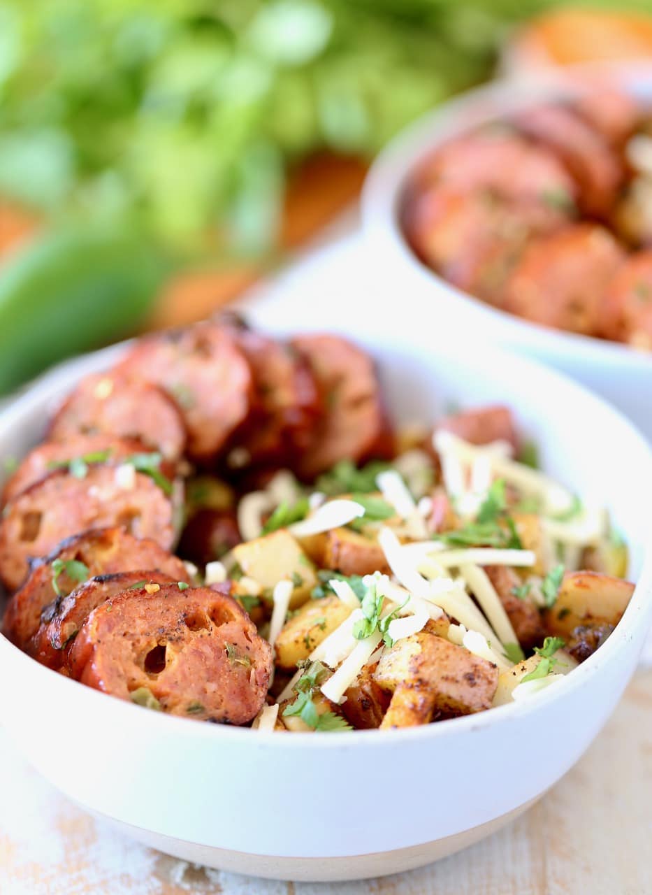 Grilled Sausage Sliced in Bowls with Potatoes, Cheddar Cheese and Cilantro