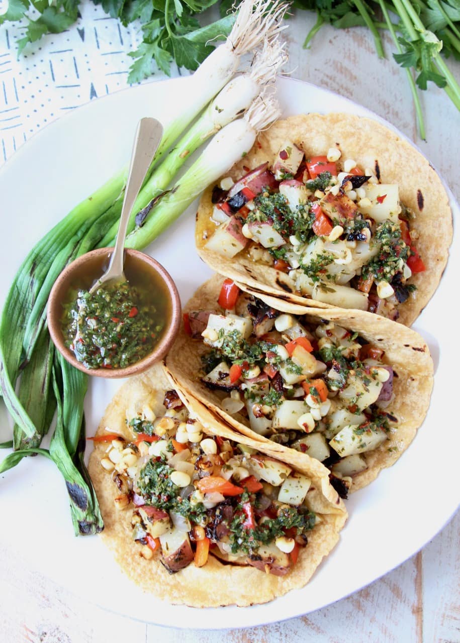Vegan Tacos filled with Grilled Potatoes, Peppers and Onions, Chimichurri Sauce and Grilled Green Onions
