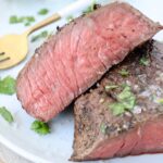 sliced medium rare sous vide steak on plate with fork
