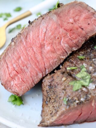 sliced medium rare sous vide steak on plate with fork