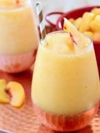 Frozen Peach Sangria in Glasses on Copper Tray with Fresh Peaches in Red Colander