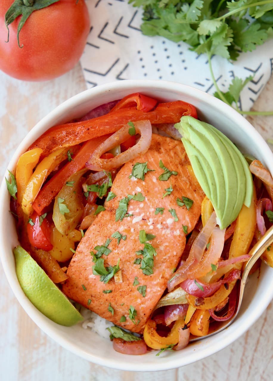 Baked Salmon Fajitas with Bell Peppers and Onions, Sliced Avocado and Lime Wedge in Bowl with Rice