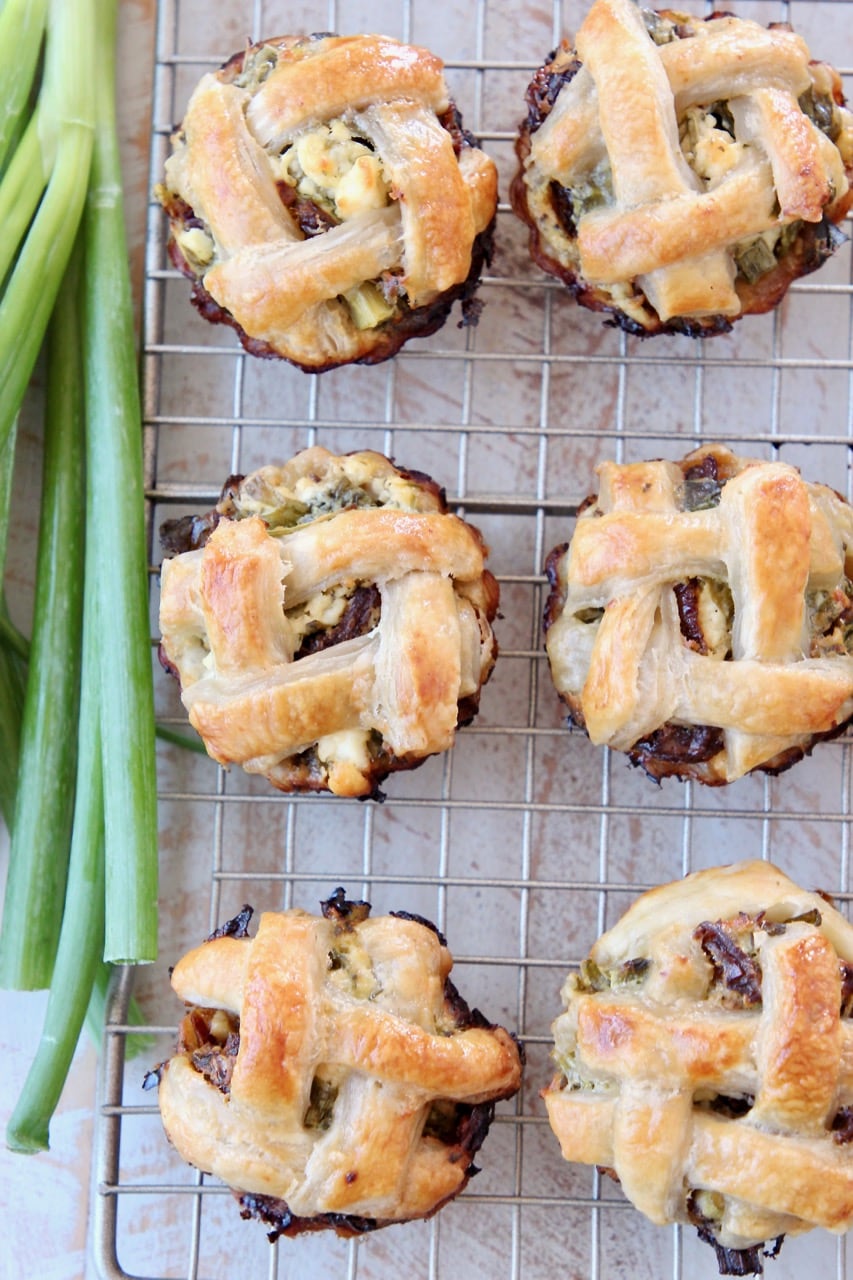 Spinach Feta Mini Pies with Braided Puff Pastry Crust on Wire Baking Rack with Green Onions