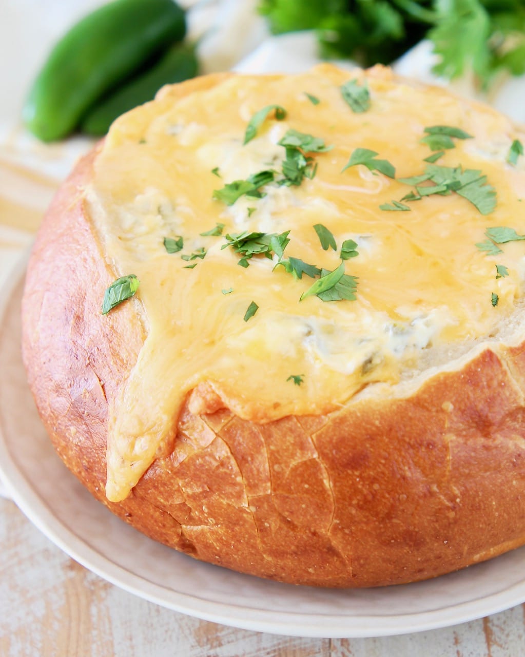 Cheesy sourdough bread bowl with fresh jalapenos and cilantro