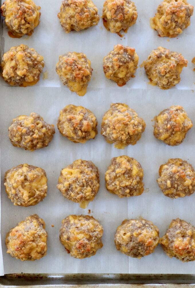 cooked sausage balls on parchment-lined baking sheet