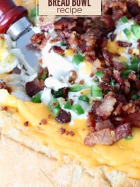 A close-up of a jalapeño popper bread bowl topped with melted cheese, bacon bits, and chopped jalapeños, conveying a savory and appetizing look. A spatula is partially visible, suggesting serving. Text overlay reads "5 Ingredient Jalapeno Popper Bread Bowl Recipe."