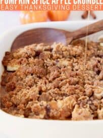 Apple crumble in baking dish with wooden spoon