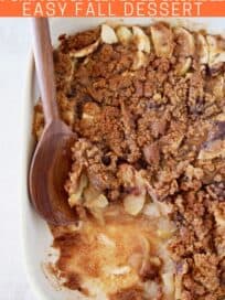 Apple crumble in baking dish with wooden spoon