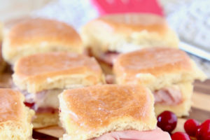 Cranberry Brie Ham Sliders on Hawaiian Rolls - image with text overlay "Super Easy, 4 ingredient Cranberry Brie Ham Sliders WhitneyBond.com"
