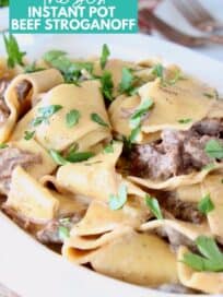 beef stroganoff with thick egg noodles in a white serving bowl