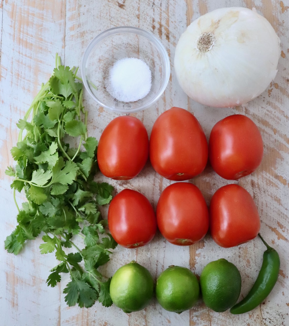 ingredients for pico de gallo on a white wood board