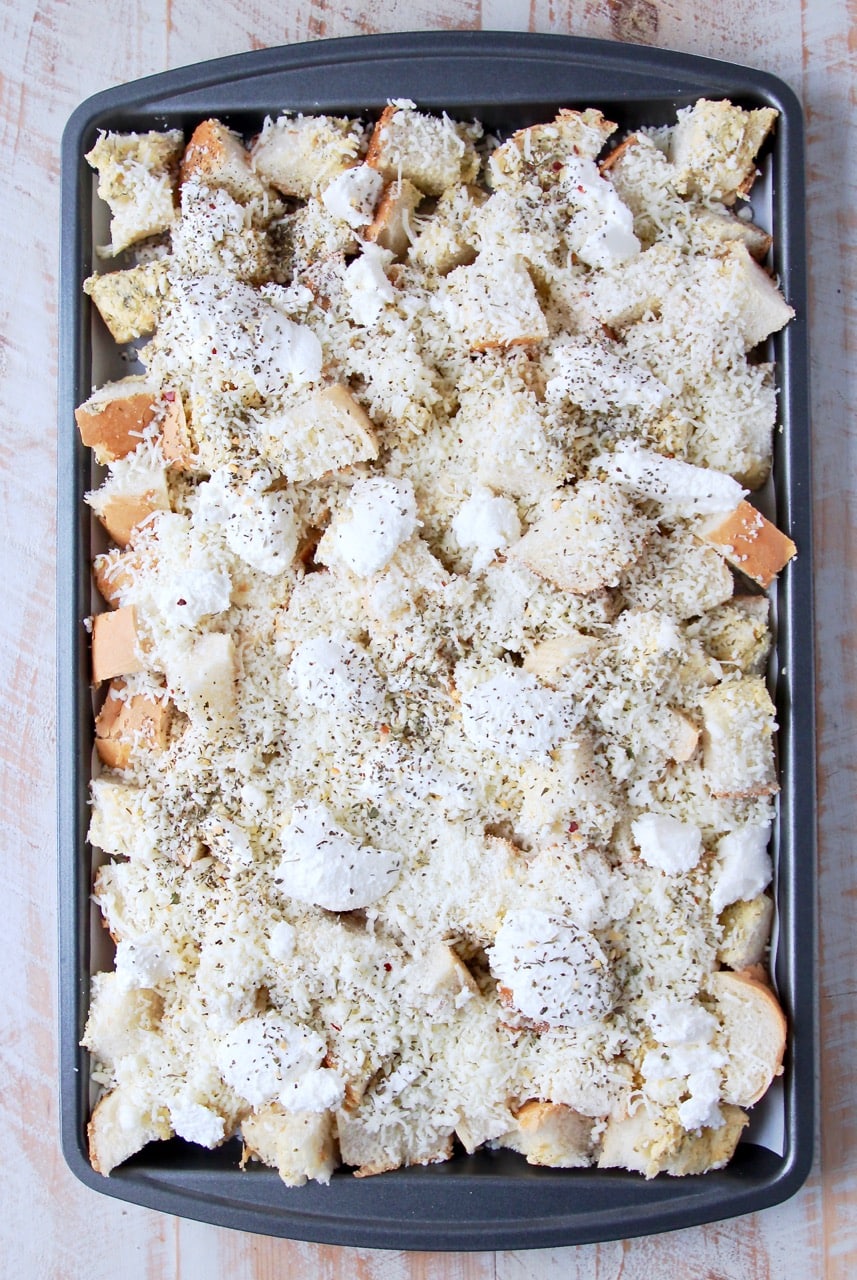 Garlic bread covered in cheese on a baking sheet