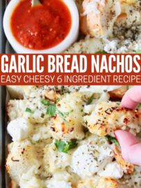 Close-up of garlic bread nachos topped with cheese and herbs, with a side of red sauce in a bowl. A hand is picking up a piece. Text overlay reads "Garlic Bread Nachos: Easy Cheesy 6 Ingredient Recipe."