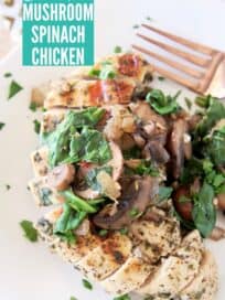 Sliced chicken breast on plate topped with sliced mushrooms and spinach