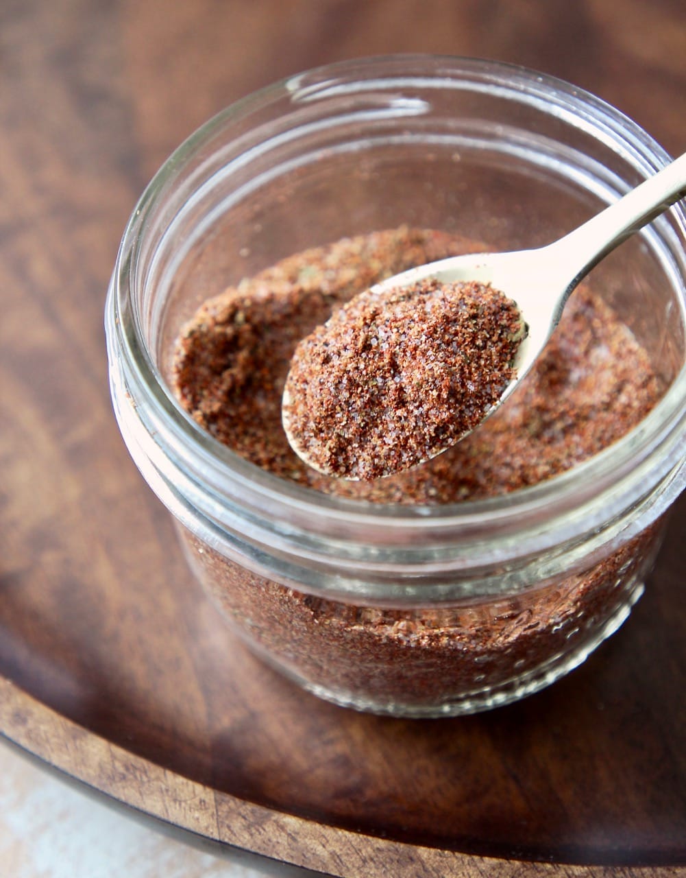 Fajita seasoning blend in a mason jar with a gold spoon full of the seasoning