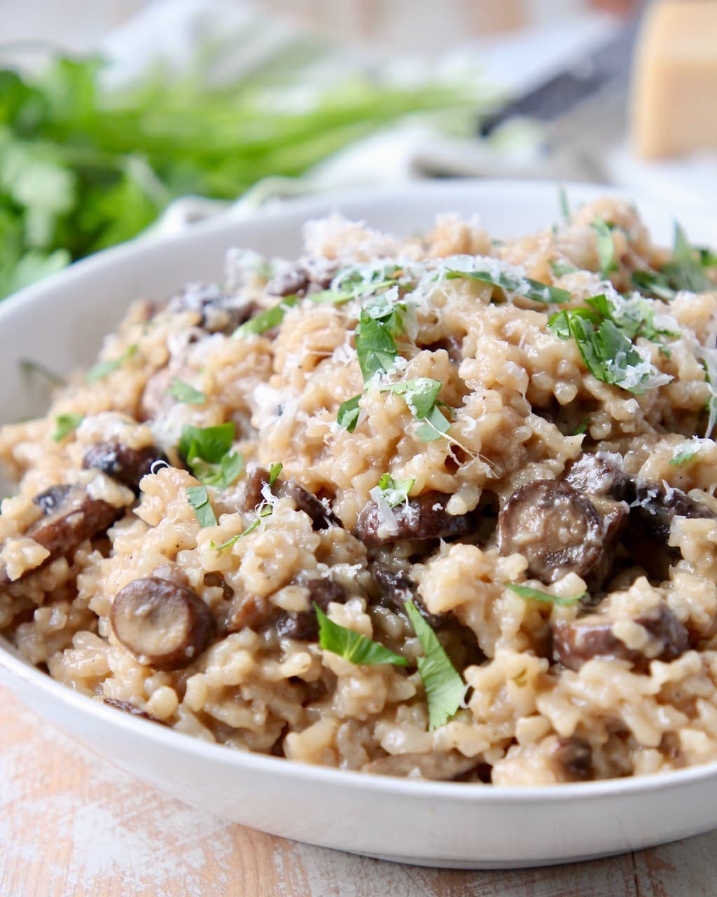 Instant pot mushroom risotto in bowl with fresh parsley and parmesan cheese