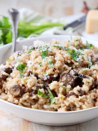 Mushroom risotto in bowl with parmesan cheese and spoon