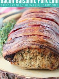 Bacon wrapped pork loin on wood cutting board