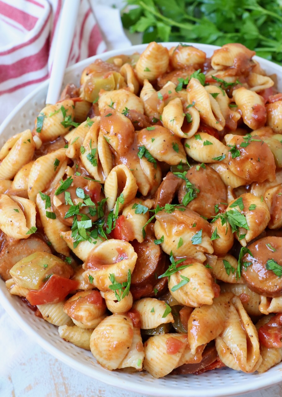 cajun pasta with sausage and peppers in a large bowl with a fork