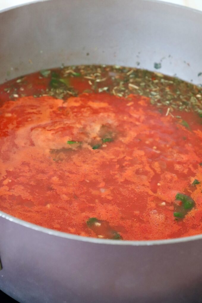 tomato sauce with Italian seasoning simmer in pot on the stove