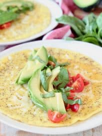 Avocado omelette topped with fresh basil, sliced avocado and fresh diced tomatoes