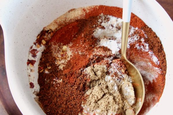 Chili seasoning mix of 8 spices in a bowl with a white and gold spoon