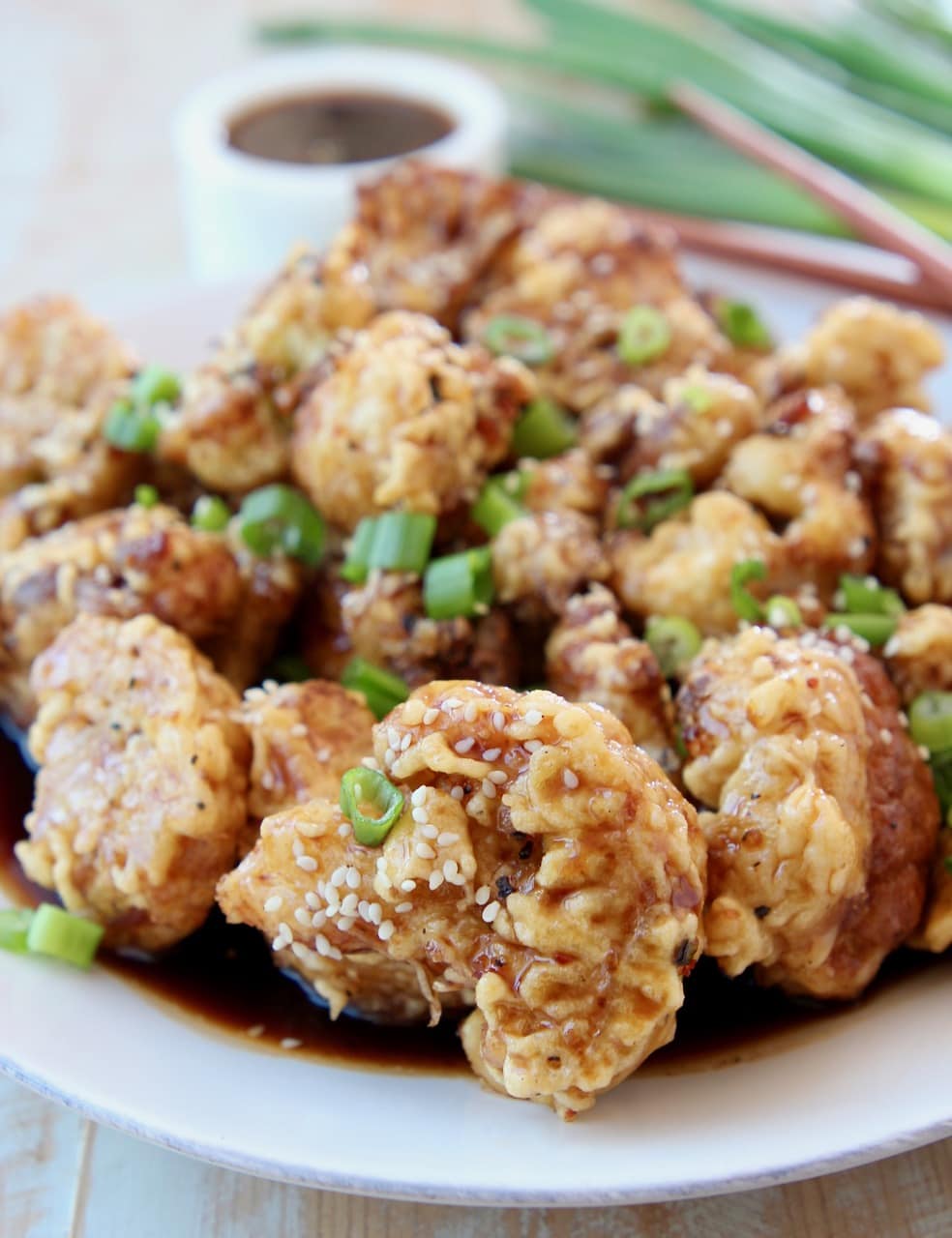 Fried Cauliflower in Korean BBQ Sauce on plate topped with diced green onions