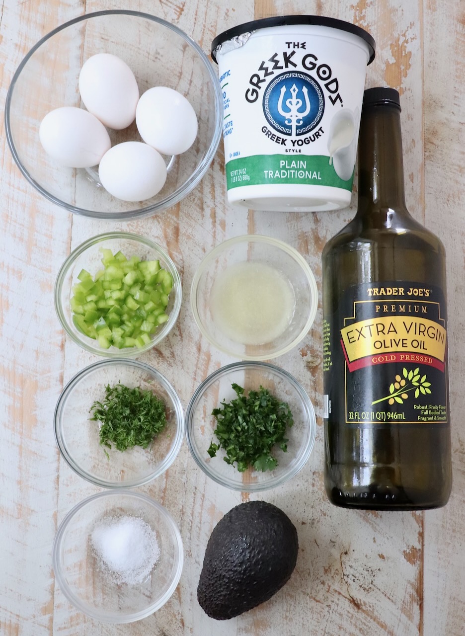 ingredients for avocado egg salad on white wood board