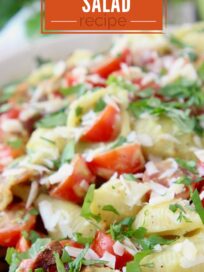 pasta salad in a bowl with diced tomatoes and bacon