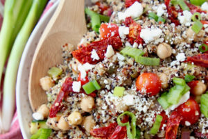 Overhead shot of quinoa salad in bowl with sun dried tomatoes and diced green onions