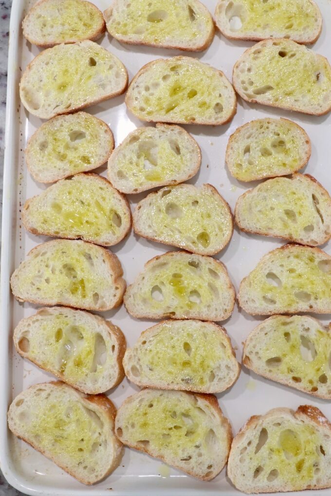 slices of baguette brushed with oil on a baking sheet