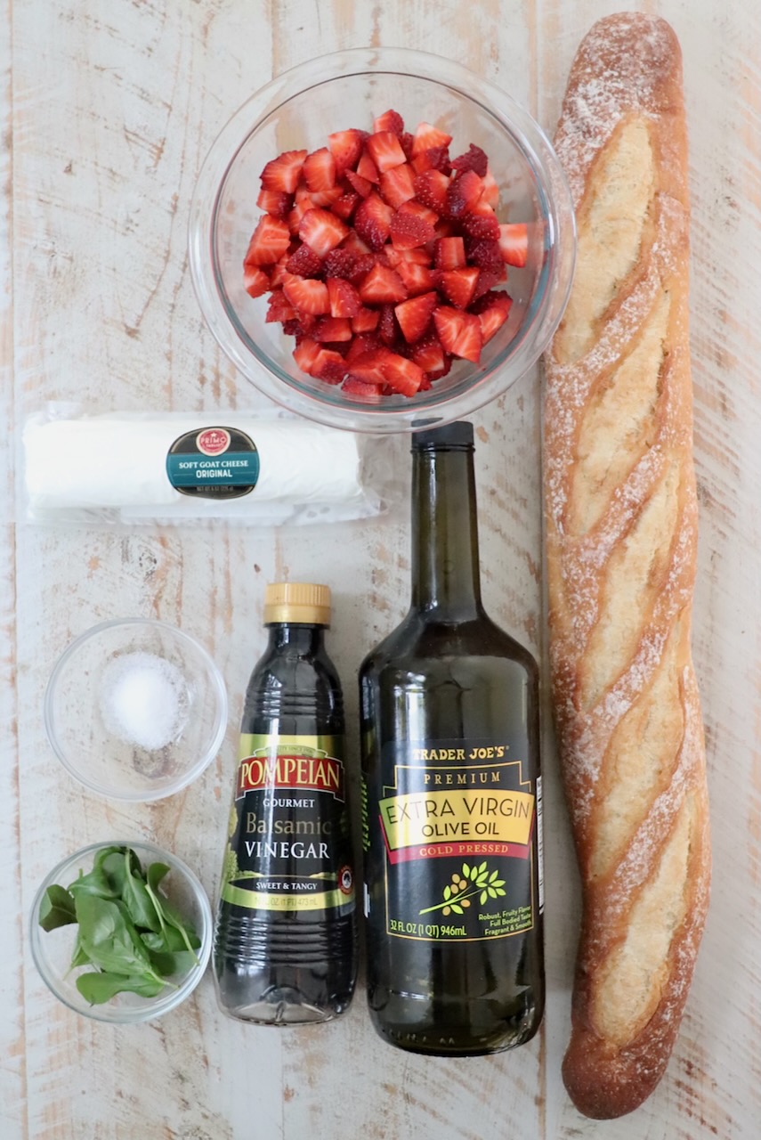 ingredients for strawberry balsamic bruschetta on a white wood board