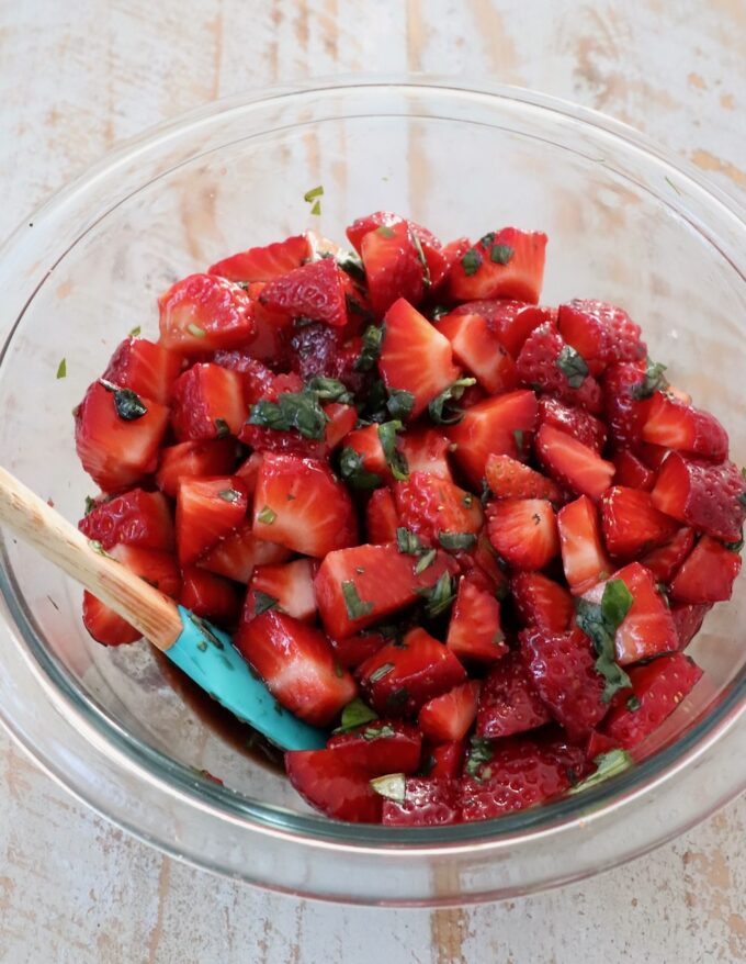 diced strawberries in a mixing bowl with balsamic vinegar and fresh basil