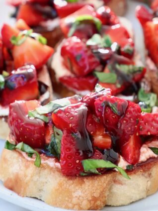 diced strawberries with fresh basil on a toasted piece of bread on a plate