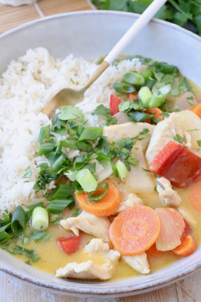 yellow chicken curry in bowl with vegetables and rice