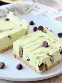 Frozen avocado cheesecake bars on plate with chocolate chips
