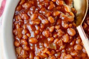 BBQ baked beans in bowl with serving spoon in the beans