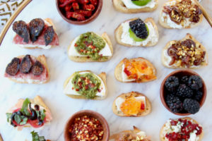 Crostini with various toppings on marble serving tray