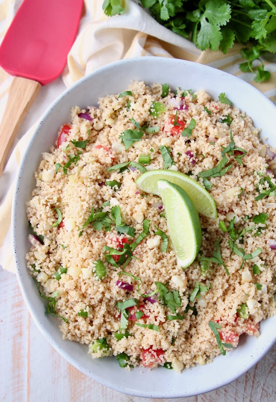 Mexican couscous in white bowl with lime wedges on top