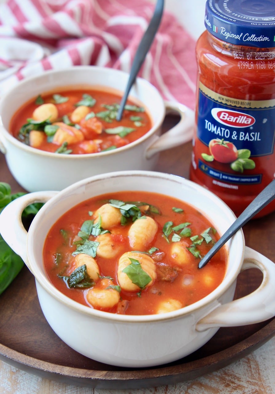 Gnocchi soup in white crocks with spoons