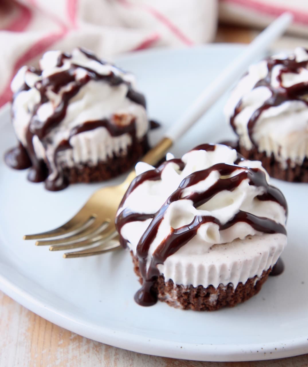 Mini chocolate ice cream cakes on a plate topped with chocolate syrup