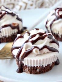 Chocolate ice cream cakes topped with whipped cream and chocolate syrup on plate with fork