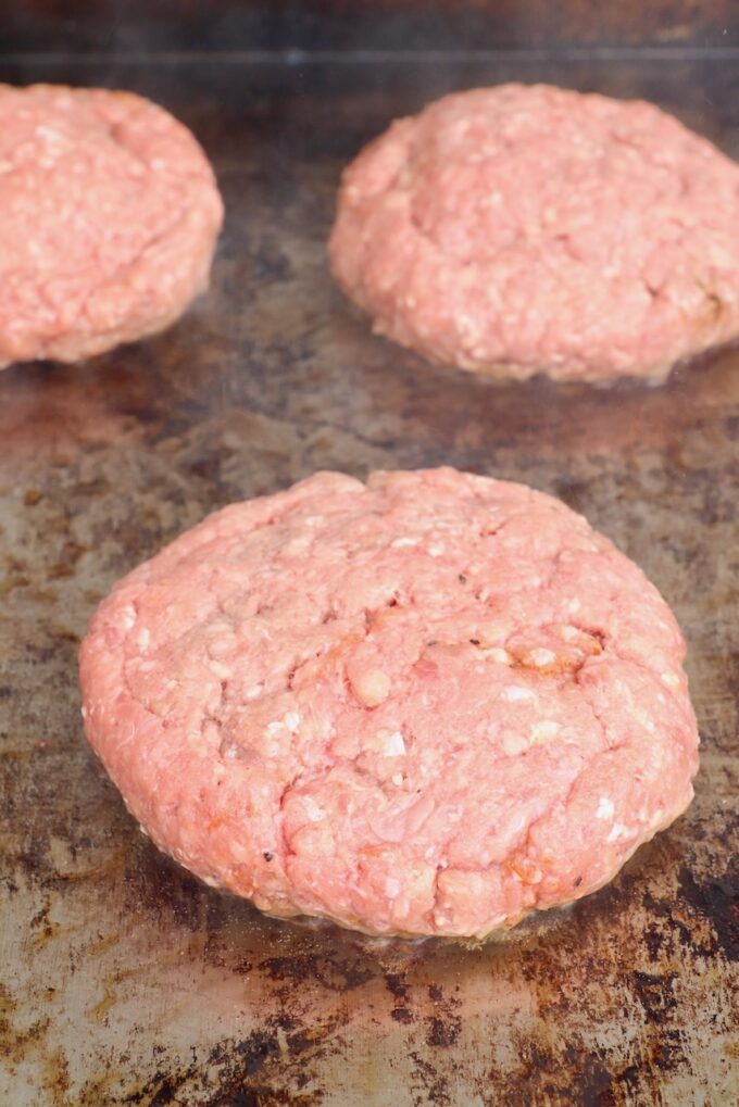 stuffed burger patties on a griddle