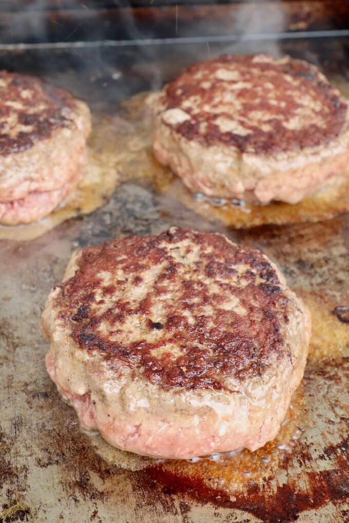 griddle stuffed burger patties on a flat top
