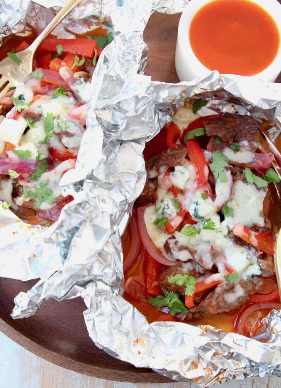 Steak, peppers, onions and melted cheese in foil pack