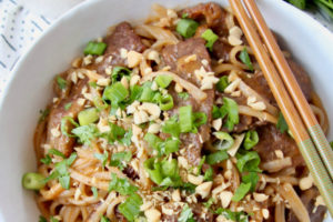 Beef and noodles in bowl with chopsticks on the side