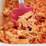 Shredded buffalo chicken with red serving spoon